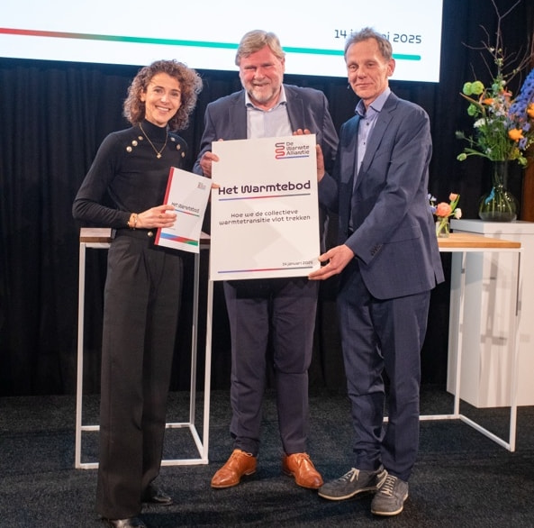 Foto van Minister Hermans ontvangt uit handen Teun van Bokhoven en Kees Vendrik het Warmtebod